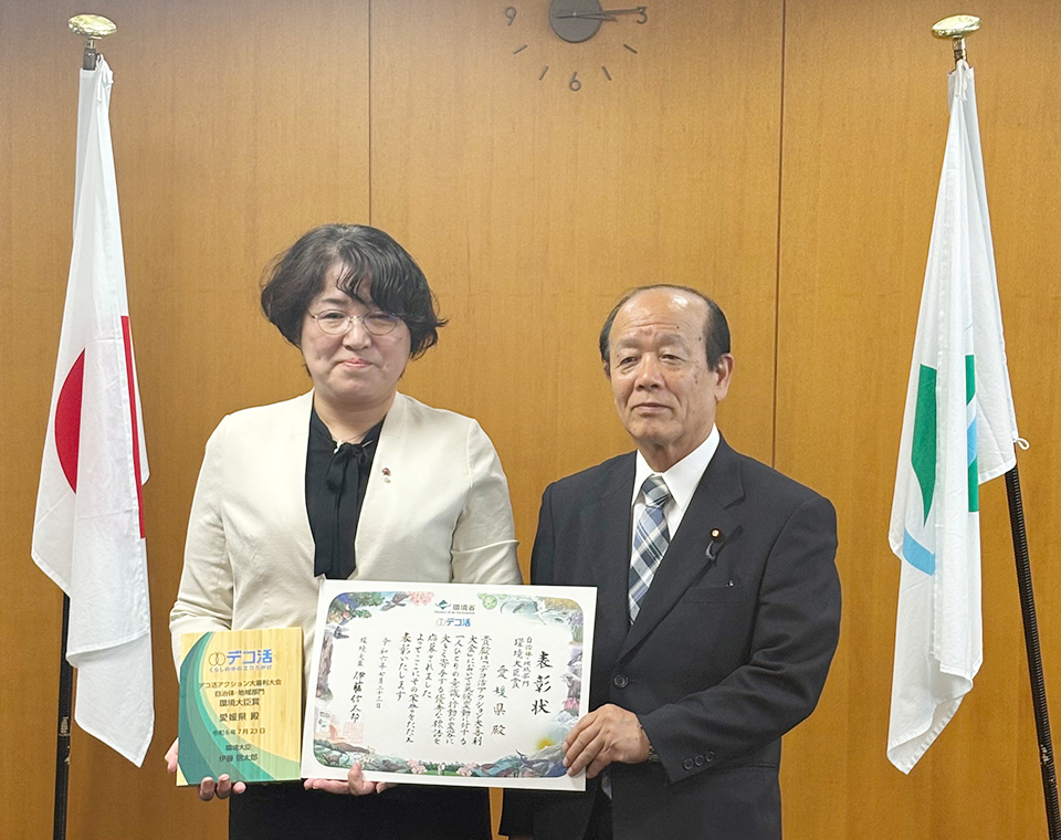 自治体・地域部門受賞　愛媛県の代表の方と八木環境副大臣。表彰状と表彰楯を手にしています。