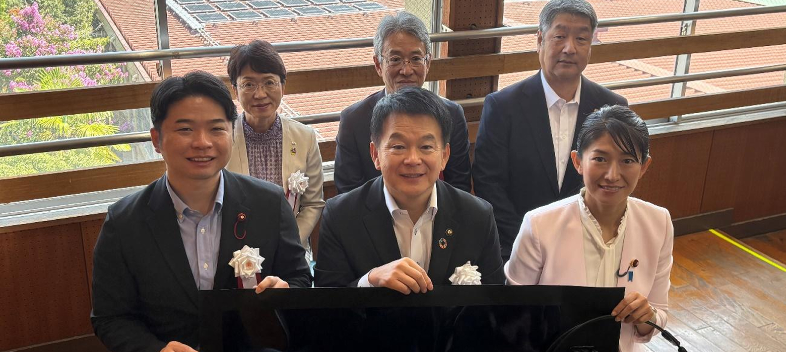 ペロブスカイト太陽電池のフィルムを持つさいたま市の清水勇人市長と環境省の森下千里政務官の写真